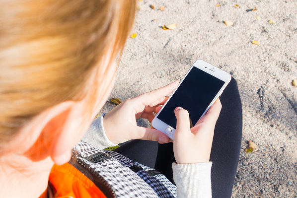 An image of a girl holding a mobile phone device