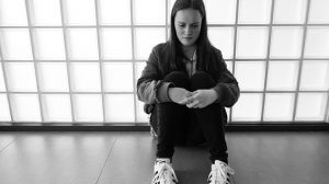 Teenager sitting on floor