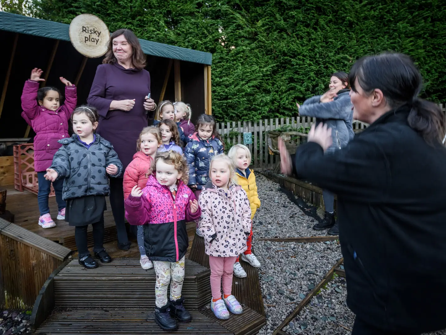 Dame Rachel de Souza standing with a group of children at risky play