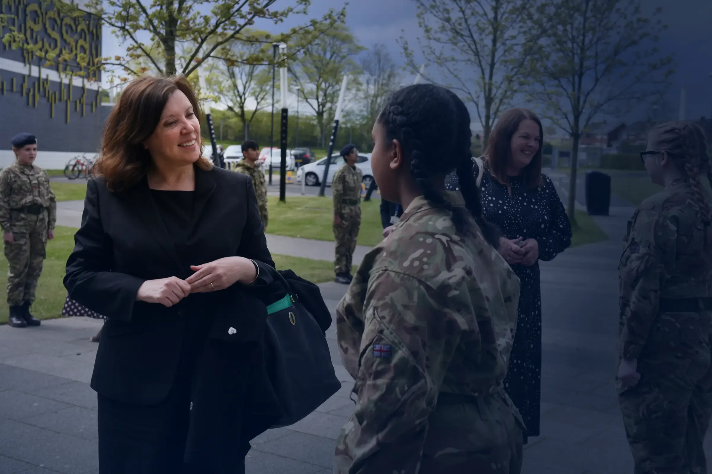 Dame Rachel de Souza talking to a young girl in a army uniform